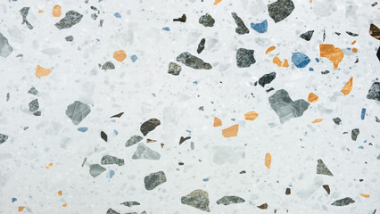 Poster - A white background with a lot of different colored rocks scattered all over it. The rocks are of various sizes and shapes, creating a visually interesting and textured surface. Scene is one of chaos