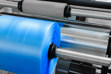 Poster - Automatic polyethylene plastic bag production machine with lighting effect. Close-up of the roller of the plastic bag production machine in the light blue scene. product packaging concept