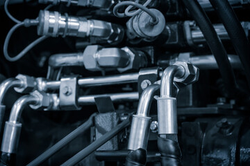 Aufkleber - A close-up of a bundle of pipes and wires of an industrial hydraulic machine. The concept is of complexity and technicality, as the various components are intricately connected and interdependent.
