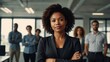 © Muqaddas - A professional black woman standing with arms crossed in a sleek office, symbolizing pride and career success