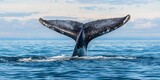 World whale day with marine and habitat idea. Whale tail emerging from ocean water under a cloudy sky.
