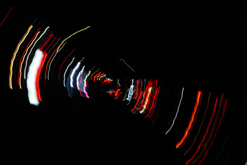 Wall Mural - Abstract blurred colorful light effect on a black background. Long exposure photo of moving camera.