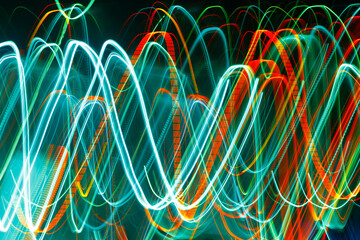 Wall Mural - Abstract blurred colorful light effect on a black background. Long exposure photo of moving camera.