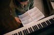 © milanmarkovic78 - Woman Playing Piano While Reading Sheet Music