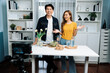 © InfiniteFlow - Cooking show on live streaming with two chef influencers teaching mixed salad with dressing for easy special recording on video camera. Ingredients placing bread bun wholegrain side dish. Infobahn.