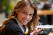 © Yuliia - Joyful Young Female Business Professional Using Calculator to Determine Total Bill