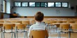 © Y_Malashkevych - A young boy sits isolated at a desk in an empty classroom his face reflecting sadness