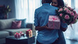 © Jafree - Romantic African American couple embracing with a gift and pink roses in a cozy living room. Concept of love, surprise gifting, intimate moments. Valentine's Day. Copy space