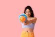 © Pixel-Shot - Happy African-American woman with water gun on pink background