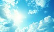 © Hamsya - Bright sun shining through fluffy white clouds in a clear blue sky, ideal for backgrounds
