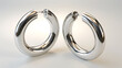 © Arslan - A pair of elegant silver hoop earrings with a shiny finish, isolated on a white background.