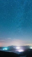 Wall Mural - bright city lights and majestic night sky, time lapse view