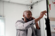 © Parichat - Businessman explaining strategy during phone call and pointing at whiteboard during a presentation in the office