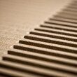 © homydesign - Close-up of corrugated cardboard with parallel lines and textured surface creating a simple geometric pattern