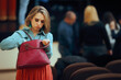© nicoletaionescu - Forgetful Woman Checking her Purse at a Public Event. Lady with a messy, cluttered handbag losing her stuff