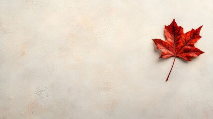 Leinwandbilder - A single autumn leaf in vivid red and orange hues rests on a soft beige surface, emphasizing the detailed veins and creating a warm, inviting atmosphere
