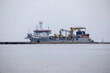 © Jorens - a large gray freighter with a yellow lift docked.