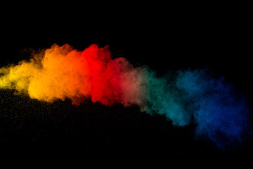Wall Mural - throw color powder on dark background.explosion of colored powder isolated on black background.