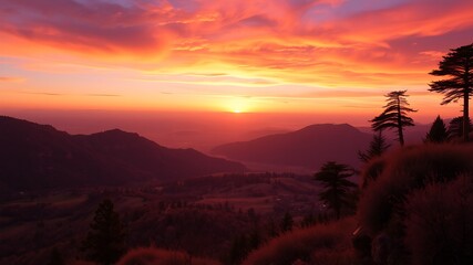 A breathtaking sunset over rolling hills and valleys, casting a fiery orange glow on the landscape, silhouettes of trees on a mountaintop.