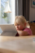 © Westend61 - Portrait of sad little girl using digital tablet at home