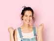 © Westend61 - Portrait of young cheering woman with black hair in front of pink background