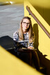 © Westend61 - Portrait of blond student with notebook sitting on stairs outdoors