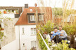 © Westend61 - Young couple relaxing on their balcony, sitting on couch