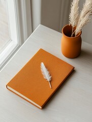 Poster - Minimalist Workspace Aesthetic Rust-Colored Notebook with Feather Pen on Light Wood - Creative Content for Modern Office Ambiance and Lifestyle Branding