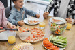 © sofiko14 - Caucasian family including young girl enjoying breakfast with pizza, salad, and orange juice. Relaxed morning gathering around dining table highlighting family togetherness and casual dining at home.