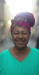 Wall Mural - Happy senior african woman wearing traditional clothes and smiling on camera in the city - Culture, urban and elderly lifestyle concept 