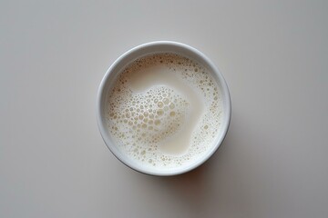 Poster - Top view of a bowl of frothy milk, creating intriguing bubble patterns on a minimalist background