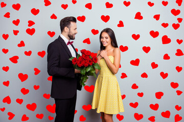 Aufkleber - Bearded gentleman in tux with bowtie presenting bouquet of red roses to his charming cute sexy girlfriend in yellow dress on 14 february, wife and huwband on grey background