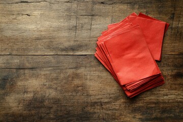Poster - Bright Red Paper Sheets Stacked on a Rustic Wooden Table Surface