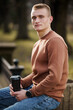 © Galka3250 - Young man enjoying coffee in a serene outdoor setting