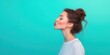 © StockKing - Charming profile of a woman blowing air kisses in a white t-shirt against a vibrant teal turquoise background with soft lighting contrasts
