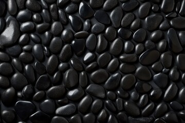 Poster - Modern arrangement of smooth black pebbles showcasing natural beauty and texture under bright lighting