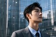 © haiqiang - arafed asian man in a suit and tie standing in front of a building