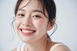 smiling asian woman with long black hair and white tank top