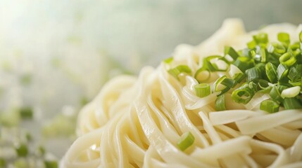 Poster - Close up of a tempting noodle dish topped with fresh chopped green onions against a soft blurred background with space for text.