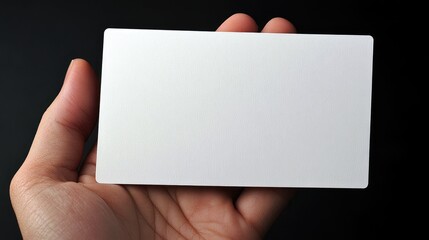 Fototapete - Close up of a hand presenting a blank business card ready for customization and personal branding on a dark background