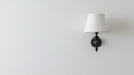 Poster - Elegant wall-mounted lamp with pleated shade illuminating a minimalist white wall, featuring ample copy space for text or branding.