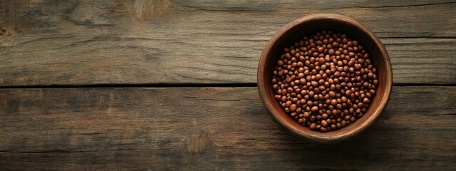 Poster - Dried brown peas in a wooden bowl on a rustic table with ample space for text or graphic overlay for culinary or health themes.