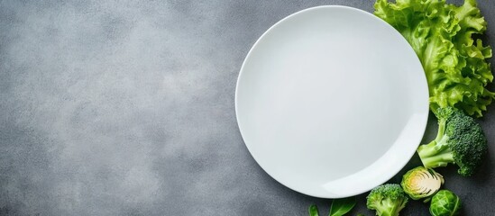 Poster - Fresh vegetables on a white plate with empty space for text on a gray slate background showcasing lettuce Brussels sprouts and broccoli