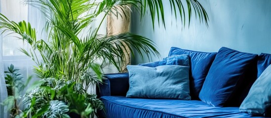 Aufkleber - Cozy modern living room with blue fabric sofa, decorative cushions, and lush indoor plants featuring ample copyspace for text.