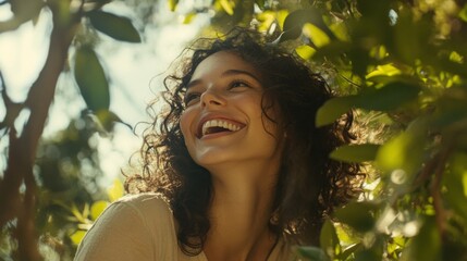 Aufkleber - A cheerful woman with curly hair surrounded by greenery, showcasing her vibrant personality and connection to nature in a sunny outdoor setting