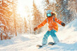 © NataliPro - A young boy in an orange jacket skiing down a snowy slope with trees in the background.