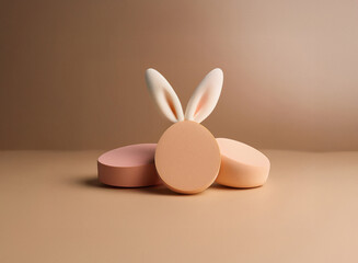 Leinwandbilder - Three pastel-toned cylindrical forms, with a pair of bunny ears atop the central piece, sit on a matching background.  A minimalist Easter-themed image.