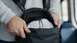 © Ponchita - Close-up of a Man Efficiently Packing a Stylish Backpack for a Short Business Trip, Highlighting Organization and Minimalism