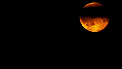 Wall Mural - Time lapse of a dramatic yellow red moon passing, moving up, few clouds in the dark night background, copy space, darkness, only moon
