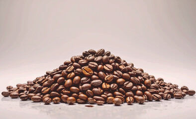 Aufkleber - A pile of coffee beans on a white surface. The beans are of different sizes and are spread out in a pile